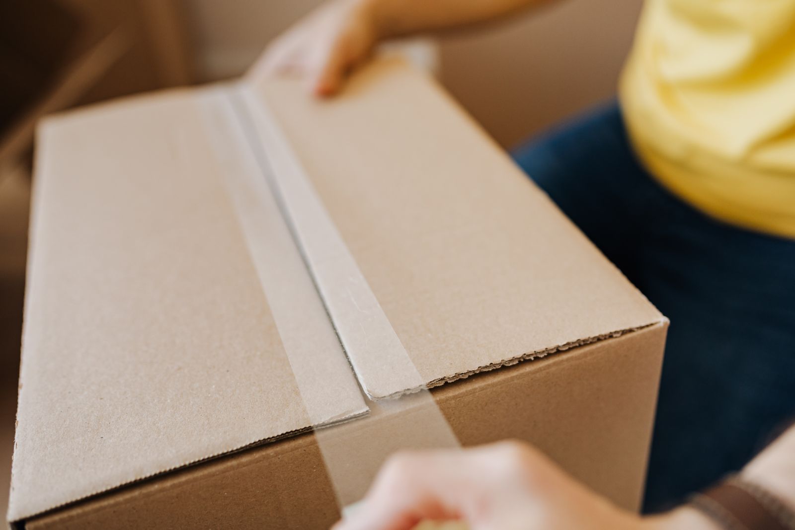Sealing a moving box with tape, ready for the road